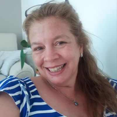 Liz Hosford smiles in a blue and white top